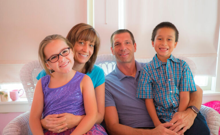 A happy smiling family, with adopted children.