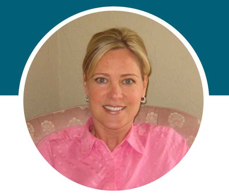 Lady smiling while wearing a pink button up blouse