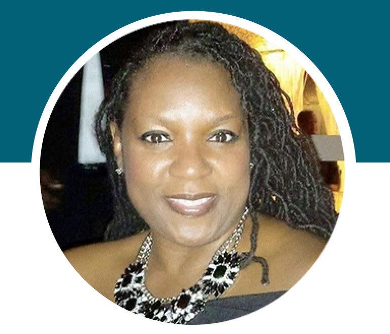 Lady smiling wearing a black and white necklace.